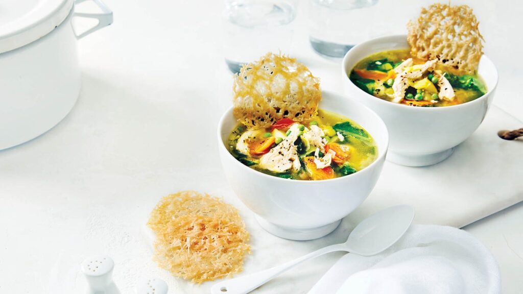 Soupe de légumes printaniers avec poulet effiloché et chips de parmesan